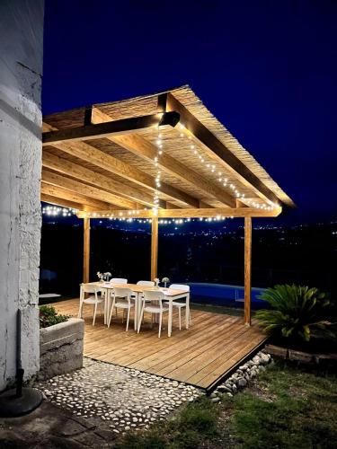 a pavilion with tables and chairs on a deck at night at Casa Amrita B&B in Teramo