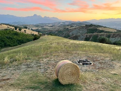 a bale of hay on a hill with mountains in the background at Casa Amrita B&B in Teramo