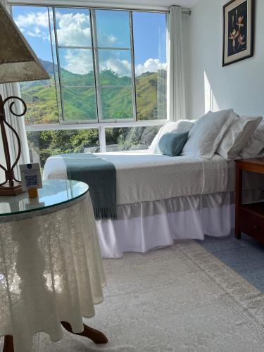 a bedroom with a bed and a large window at Albergue Turístico Gstir in Pozuzo