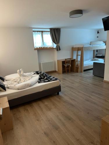 a bedroom with a bed in a room with wooden floors at LE 4 STAGIONI in Cavedago