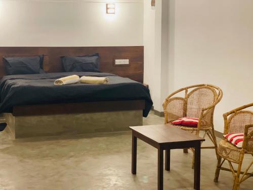 a bedroom with a bed with two chairs and a table at Ashansa Lagoon Resort in Tangalle
