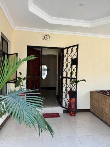 an open door into a room with a plant at Maasai house in Arusha