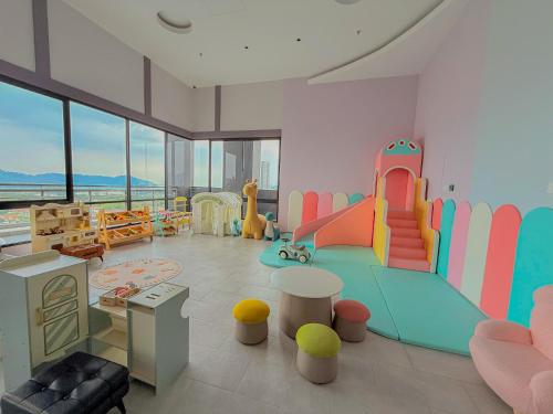 una sala de juegos para niños con un tobogán y un parque infantil en Iconic Regency Service Residences - Bee's Home, en Bayan Lepas