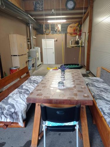 a room with a wooden table and a bed at Little Joy Lodge , Loč Mala Radost in Bihać