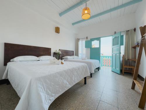 a bedroom with two beds with white sheets at Casa Ramona in Flores