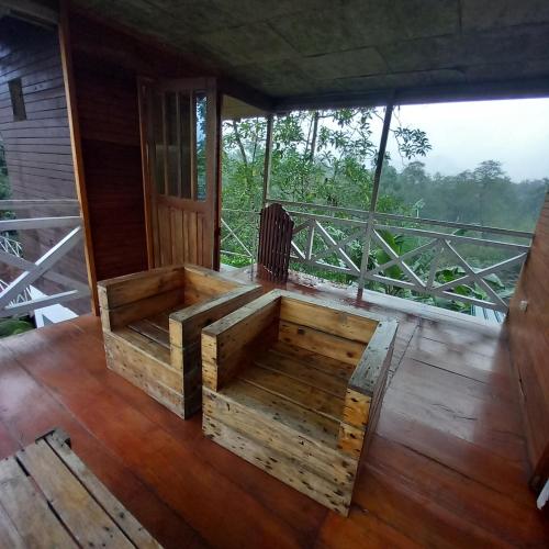 a large wooden bed on a wooden floor on a balcony at Mionga in Santa Cruz