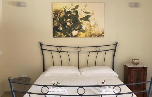 a bed in a bedroom with a picture on the wall at Naturalya in Vibonati