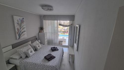een kleine kamer met een bed en een raam bij Magic holiday - 1st line, seaview, pool & parking in Ifach