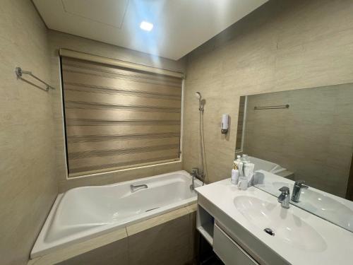 a bathroom with a tub and a sink and a bath tub at FLC Sea Tower Quy Nhơn Seaview Apartment in Quy Nhon