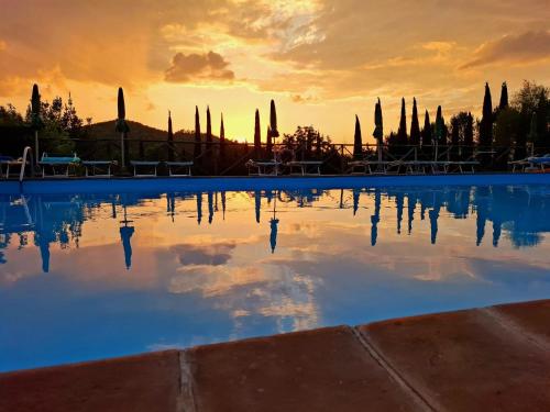 a pool of water with a sunset in the background at Le Gorghe di Valmarino in Corciano