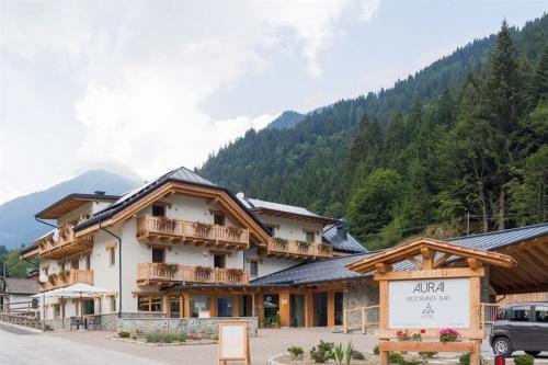a large building with a sign in front of it at Hotel Aurai in Osteria Alpina