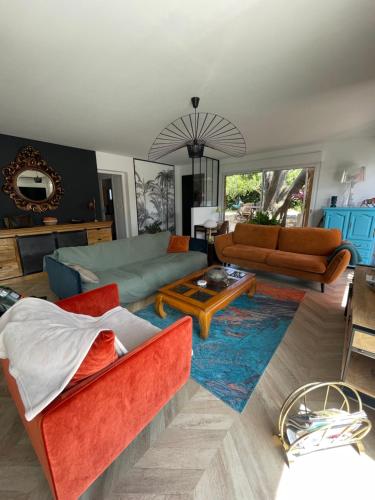 un salon avec des canapés et une table dans l'établissement Maison avec SPA et PISCINE 2 chambres, à Ajaccio