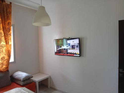 - une télévision accrochée au mur dans l'établissement luxu appart siesta beach resort, à Mohammedia