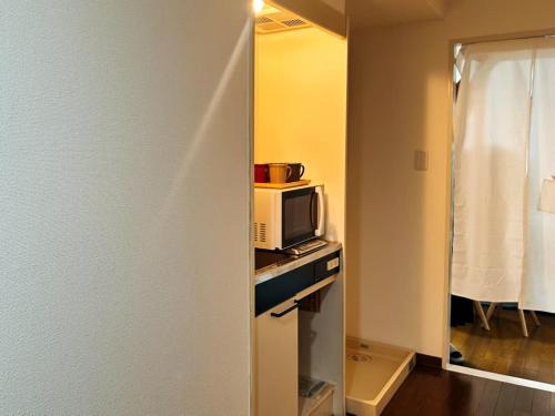 a small kitchen with a microwave on a counter at sakura 401 in Tokyo