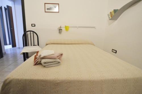 a bedroom with a bed with towels on it at Casa Vacanza Viale Arbatax in Tortolì
