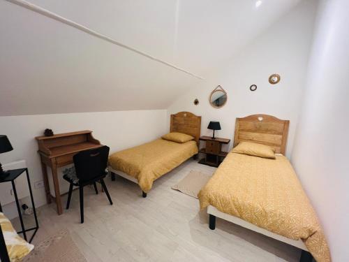 a bedroom with two beds and a desk and a table at Villa Mia in Hayange