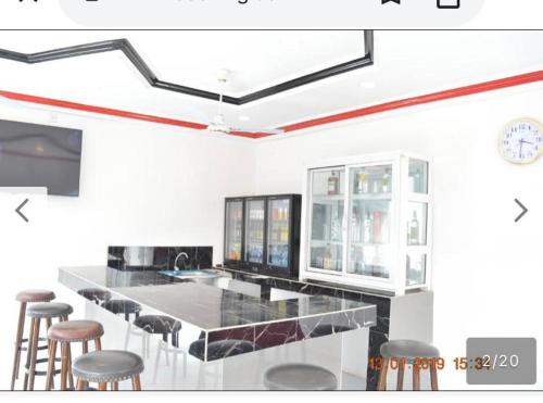 a kitchen with a long counter with stools at Sukuta nema guest house in Sareh Mowndeh