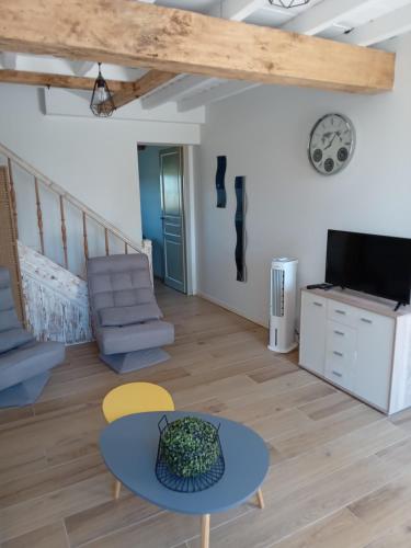 a living room with a table and a tv at Maison indépendante à la ferme in Palleville