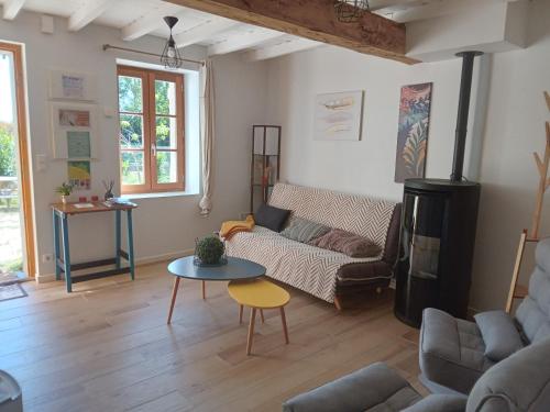 a living room with a couch and a table at Maison indépendante à la ferme in Palleville