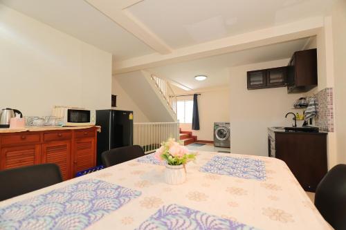 a kitchen with a table with a vase of flowers on it at The Comfort house near CMU in Chiang Mai