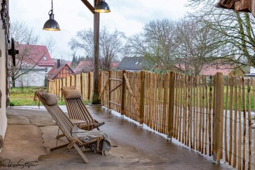 two chairs sitting on a patio next to a fence at Ferienhaus Honey Bee in Billingsbach
