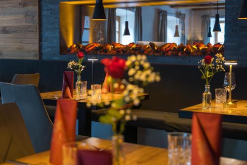 a table in a restaurant with flowers on it at Boutique Hotel beim Lipp - Restaurant & Spa in Roßhaupten