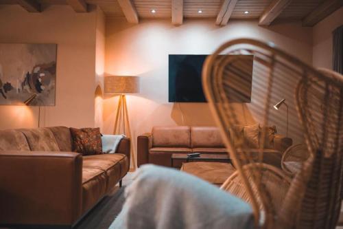 a living room with a couch and a tv at Landvilla Diebach in Diebach