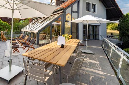 a wooden table and chairs with umbrellas on a patio at Landvilla Diebach in Diebach