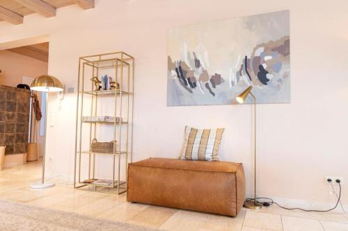 a living room with a brown ottoman and a painting at Landvilla Diebach in Diebach