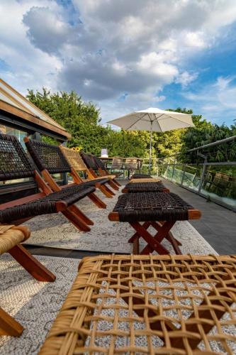 a row of tables and chairs with an umbrella at Landvilla Diebach in Diebach