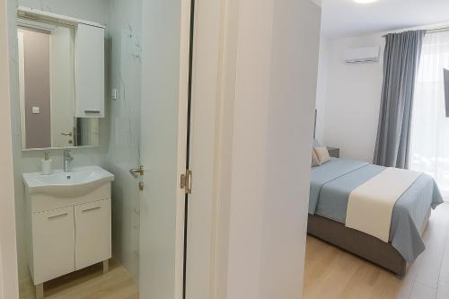 a small bedroom with a bed and a sink at Costal Retreat Budva in Becici