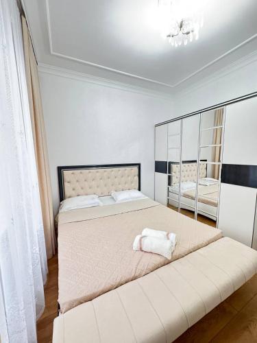 une chambre avec un grand lit avec un grand miroir dans l'établissement with a view of the mountains in the very center of the city near Arbat, à Almaty