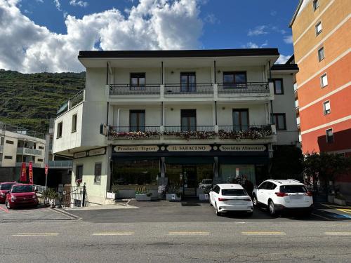 a large building with cars parked in a parking lot at Residenza Dei Parchi in Sondrio
