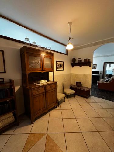 a living room with a large wooden cabinet and a chair at Residenza Dei Parchi in Sondrio