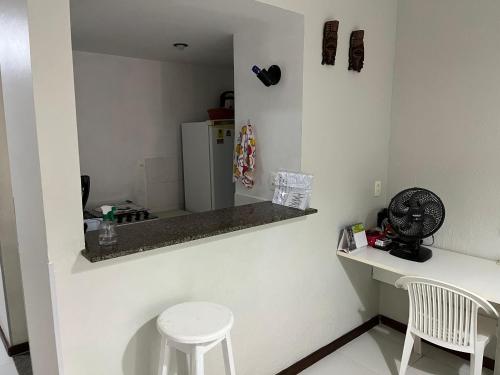 a small kitchen with a counter and a refrigerator at studio aconchegante para 02 na praia de Amaralina in Salvador