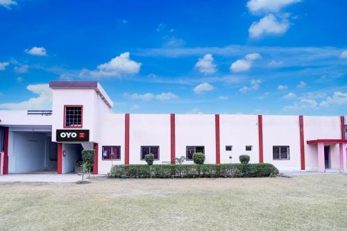 a large white building with a qos sign on it at SPOT ON JAYDEVI SEVA SADAN in Mathura