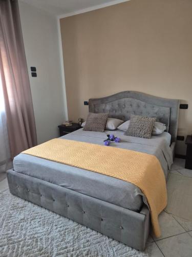 a bedroom with a large bed with a gray headboard at Casa Mario, In The Heart Of Asti in Asti