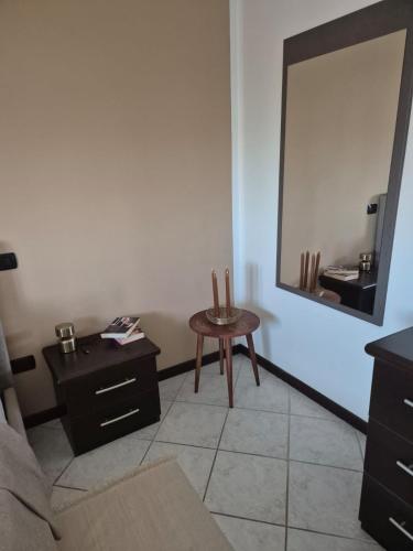 a living room with a table and a mirror at Casa Mario, In The Heart Of Asti in Asti