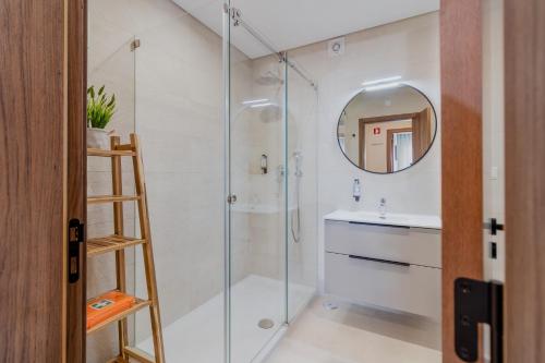 un bagno con doccia, lavandino e specchio di São Luís Faro Apartment - Algarve a Faro