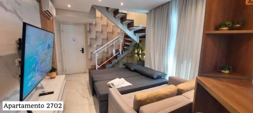 a living room with a couch and a staircase at Book Santos - Estanconfor Cobertura com Jacuzzi e Vista Mar in Santos