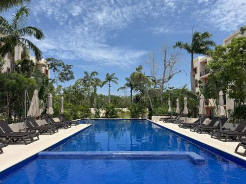 a swimming pool with chaise lounges and chairs at OMBU Apartment New, equipped, 2 bedrooms, 2 bathrooms, pool in Cancún