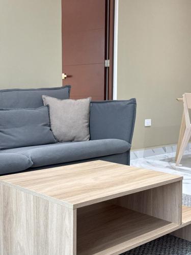 a living room with a blue couch and a wooden coffee table at OMBU Apartment New, equipped, 2 bedrooms, 2 bathrooms, pool in Cancún