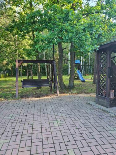 a park with a bench and a playground at Leśna Polana- Kompleks Domków Mieszkalnych in Kamionka