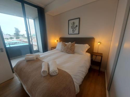 a bedroom with a bed with two towels on it at 310 The Meadows in George