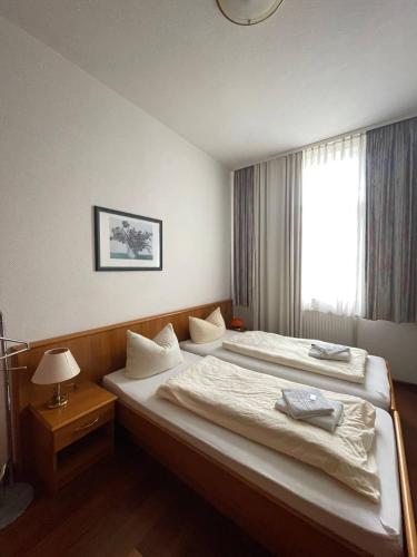 a bedroom with two beds and a window at Ferienwohnungen am Roland in Neustadt