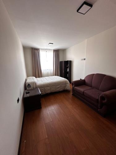 a living room with a couch and a bed at Exclusivo Departamento! in Cochabamba