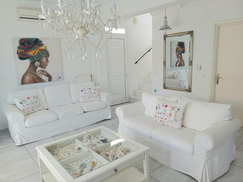 a living room with two white couches and a chandelier at OASIS VILLA in Litochoro