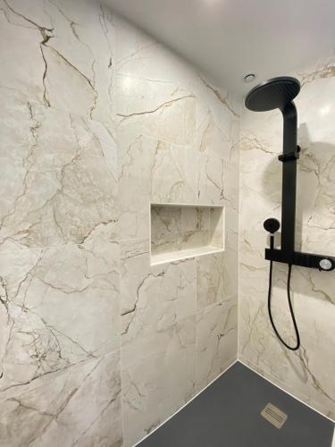 a bathroom with a white marble wall at La Logette in Les Petites-Loges