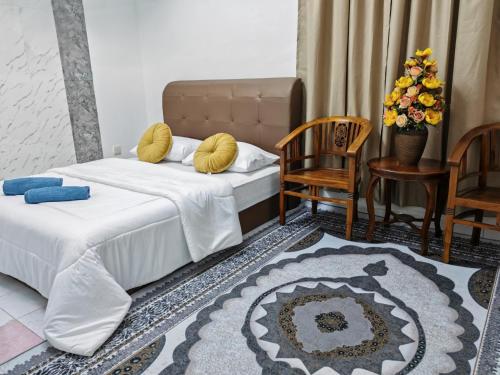 Kota BharuにあるDnRoses Innのベッド2台とテーブルと椅子のある寝室