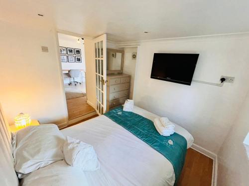 a bedroom with a bed and a flat screen tv at Hidden Gem Apartment in Torquay